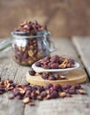 Dried hawthorn in a glass jar on a wooden ancient background.Home harvesting of dried fruits