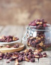 Dried hawthorn in a glass jar on a wooden ancient background.Home harvesting of dried fruits