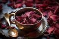 dried hibiscus petals in a teacup with a teaspoon