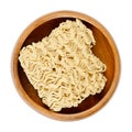 Dried instant noodles, instant ramen, in a wooden bowl