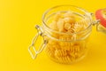 Dried italian pasta Fusilli in a open glass jar on yellow background Royalty Free Stock Photo