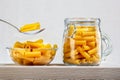 Dried italian pasta in glass bowl and jar on wooden table. Royalty Free Stock Photo