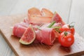 Dried jamon slices with figs on wood table Royalty Free Stock Photo