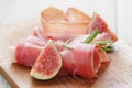 Dried jamon slices with figs on wood table Royalty Free Stock Photo