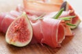 Dried jamon slices with figs on wood table Royalty Free Stock Photo