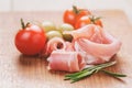 Dried jamon slices with olives and rosemary on wood table Royalty Free Stock Photo