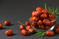 Dried Jujube, Chinese dried red date fruit with rosemary leaf in glass cup on black background