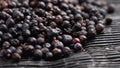 Dried juniper berries on a black paper. Dehydrated aromatic medicative ingredient.