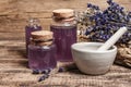 Dried lavender flowers in a in a mortar and pestle with bottle of essential lavender oil or infused water Royalty Free Stock Photo