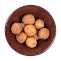 Whole dried limes, sun dried fruits in a brown ceramic bowl