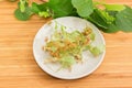 Dried linden flowers on white saucer against of fresh branch Royalty Free Stock Photo