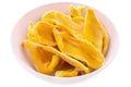 Dried mango slices in a white plate on a white background. Isolated items and products