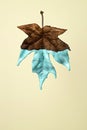 Dried maple leaf with dripping blue paint on a vanilla background Royalty Free Stock Photo