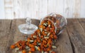 Dried marigold flowers in a glass jar for storage on a wooden background. The use of flowers Chernobrovtsy or Mary is Gold in folk Royalty Free Stock Photo