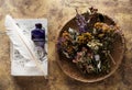 Dried medicinal herbs and herbal tea, recipe book and inkwell with feather.