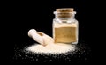 Dried milled ground garlic in wooden scoop and jar on isolated on white background. front view. spices and food ingredients