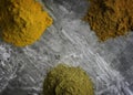 Dried mixed organic spice powders on a marble kitchen worktop background photographed from above Royalty Free Stock Photo