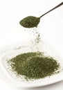 Dried moringa leaves on spoon and plate