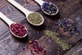 Dried myosotis Mallow flower herbal tea, Green tea and Rose flowers on spoons on wooden table Royalty Free Stock Photo