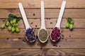 Dried myosotis Mallow flower herbal tea, Green tea and Rose flowers on spoons on wooden table Royalty Free Stock Photo