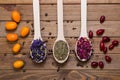 Dried myosotis Mallow flower herbal tea, Green tea and Rose flowers on spoons on wooden table Royalty Free Stock Photo