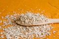 Dried oats or oatmeal in wooden spoon on the white table. Its are a nutrient-rich food associated with protein and fiber