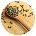 Dried okra seeds in wooden spoon, on bamboo cutting board