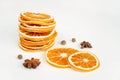 Dried orange slices stack, anise, pepper on white table background. Spices, decoration, ingredient concept.