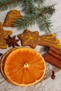 Dried orange, spices and decorated gingerbread on rustic board, Christmas time concept Royalty Free Stock Photo