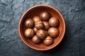 Dried organic Macadamia nuts in orange ceramic bowl