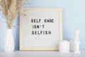 Dried pampas grass in vases, small statue, candles and felt letter board with phrase self care is not selfish Royalty Free Stock Photo