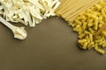 Dried pasta on the brown surface.Empty space for text