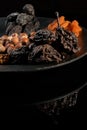 Dried pear, prunes, dried apricots on a black plate and background, selective focus. Low key. Royalty Free Stock Photo