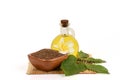 Dried Perilla seeds, green leaves and oil placed on a white background.