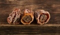 Dried Persimmon Hoshigaki. Textured wrinkled fruits on a wooden background. Useful sweets