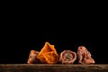 Dried persimmons on a black background. Whole fruits and slices. Place for text