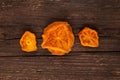 Dried persimmons. Bright orange slices on a brown wooden background. Useful sweets. Ingredients for fruit tea or punch. Selective