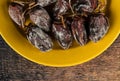 Dried persimmons on a yellow plate. On the background of wood texture