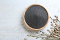 Dried poppyheads and bowl with seeds on white wooden table. Space for text