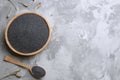 Dried poppyheads, bowl and spoon with seeds on table, flat lay. Space for text