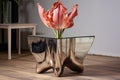 a dried potted tulip on a mirrored table reflecting the flower