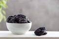 Dried prunes in a bowl on white table Royalty Free Stock Photo