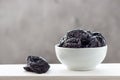 Dried prunes in a white bowl