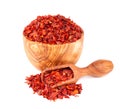 Dried red chili flakes in olive bowl and scoop, isolated on white background. Chopped chilli cayenne pepper. Spices and Royalty Free Stock Photo