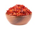 Dried red chili flakes in wooden bowl, isolated on white background. Chopped chilli cayenne pepper. Spices and herbs. Royalty Free Stock Photo