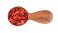 Dried red chili flakes in wooden spoon, isolated on white background. Chopped chilli cayenne pepper. Spices and herbs Royalty Free Stock Photo