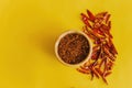 Dried red chili peppers Guajillo and chili powder spice on yellow background Royalty Free Stock Photo