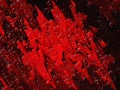 Dried red oil paint on a black background. Abstract stains resembling blood, ketchup or raspberry jam