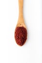 Dried red pepper flakes in the wooden spoon on white background. Royalty Free Stock Photo
