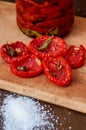 Dried red tomatoes with salt, spices and herbs on wooden board close up Royalty Free Stock Photo
